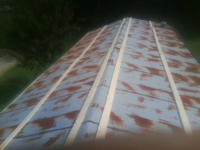 Rusted metal roof panels with new wood purlins before replacement — Storm Damage Roof Repair in Johnsonville by Roofing Brothers