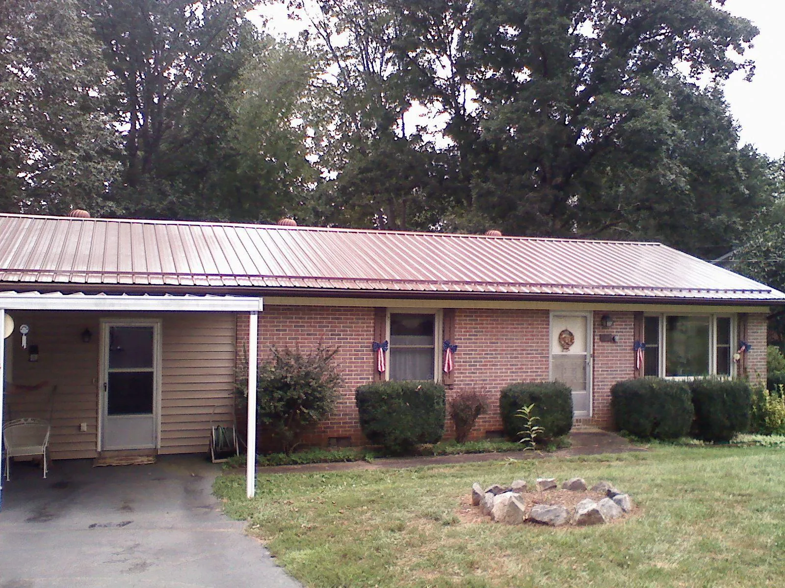 Bronze metal roof and carport on a brick ranch home — Roof Repair work by our crew in Johnsonville